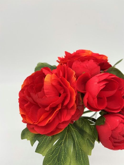 Ramillete de flores artificiales de ranúnculos rojos.
