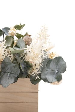 Caja de madera de pino con flores blancas secas y flores preservadas