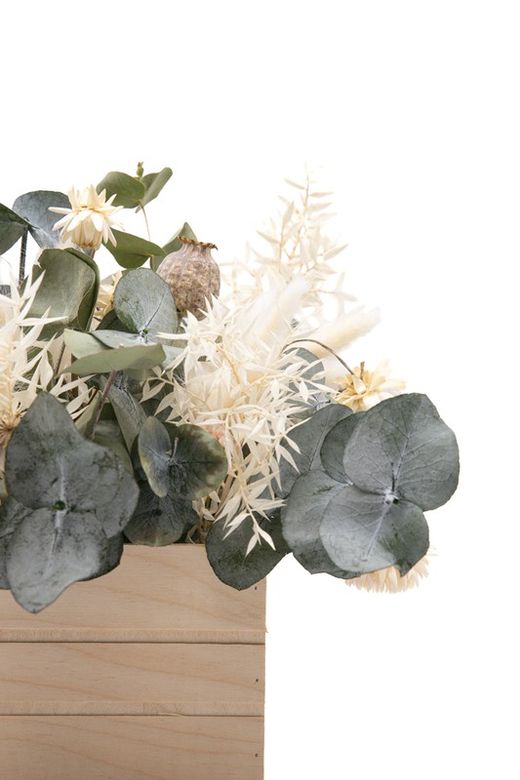 Caja de madera de pino con flores blancas secas y flores preservadas