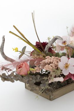 Centro alargado de flor artificial en tonos rosados, una decoración floral muy fina y elegante