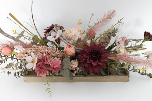 Centro alargado de flor artificial en tonos rosados, una decoración floral muy fina y elegante