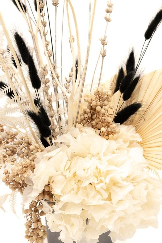 Centro alto de flores preservadas y secas en color negro y blanco.