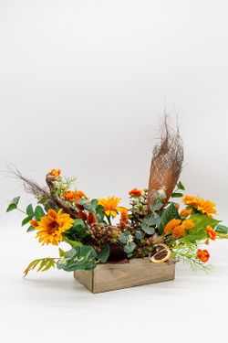 Centro de mesa alargado con flores de ranúnculo y silvestres