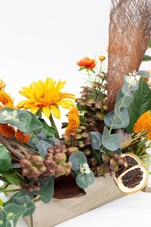 Centro de mesa alargado con flores de ranúnculo y silvestres