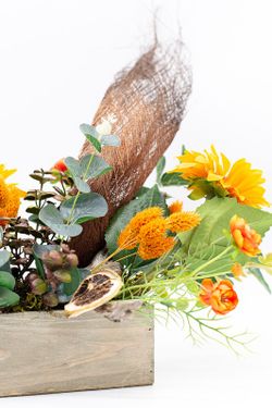 Centro de mesa alargado con flores de ranúnculo y silvestres