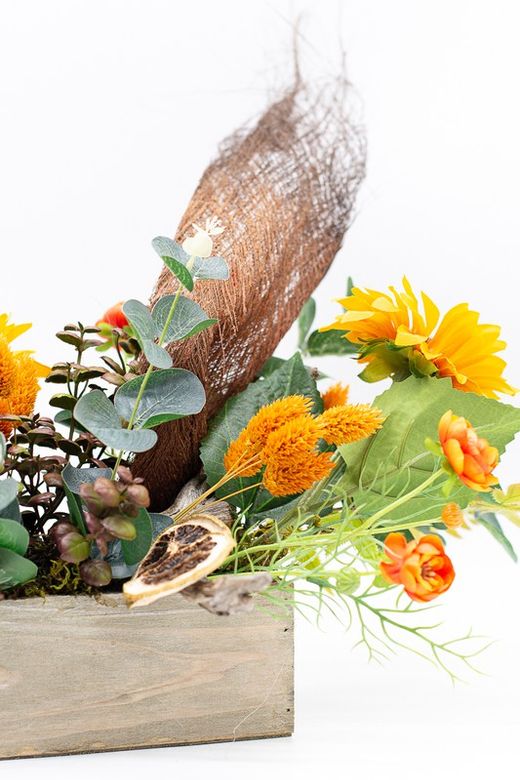 Centro de mesa alargado con flores de ranúnculo y silvestres