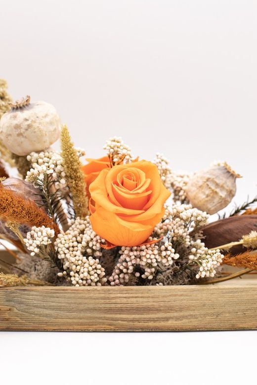 Centro de mesa alargado con rosas preservadas y materiales secos