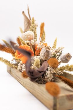 Centro de mesa alargado con rosas preservadas y materiales secos