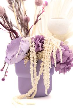 Centro de mesa en color lila con flores preservada blancas y lilas