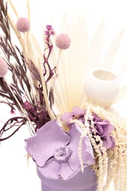 Centro de mesa en color lila con flores preservada blancas y lilas