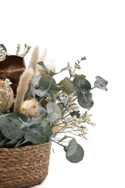 Cesta de mimbre con flores preservadas en color crema y marrón