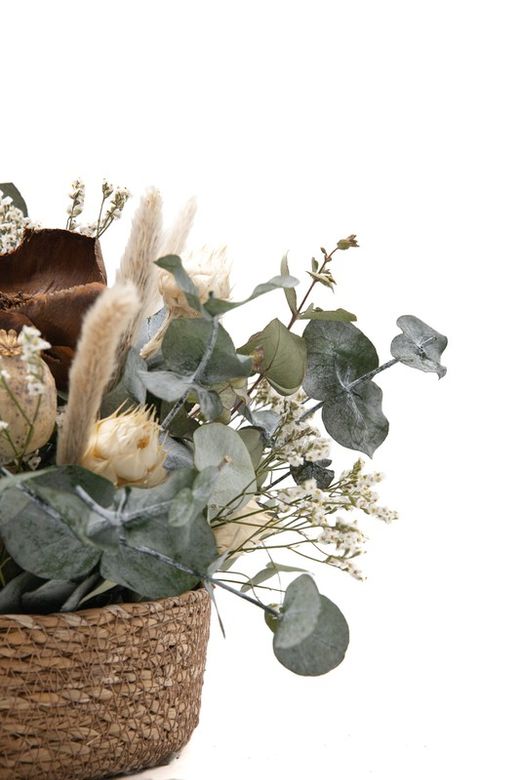 Cesta de mimbre con flores preservadas en color crema y marrón