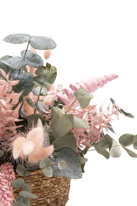 Cesta de paja natural con eucalipto preservado y flores preservadas en color rosa