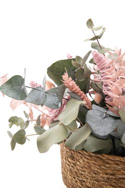 Cesta de paja natural con eucalipto preservado y flores preservadas en color rosa