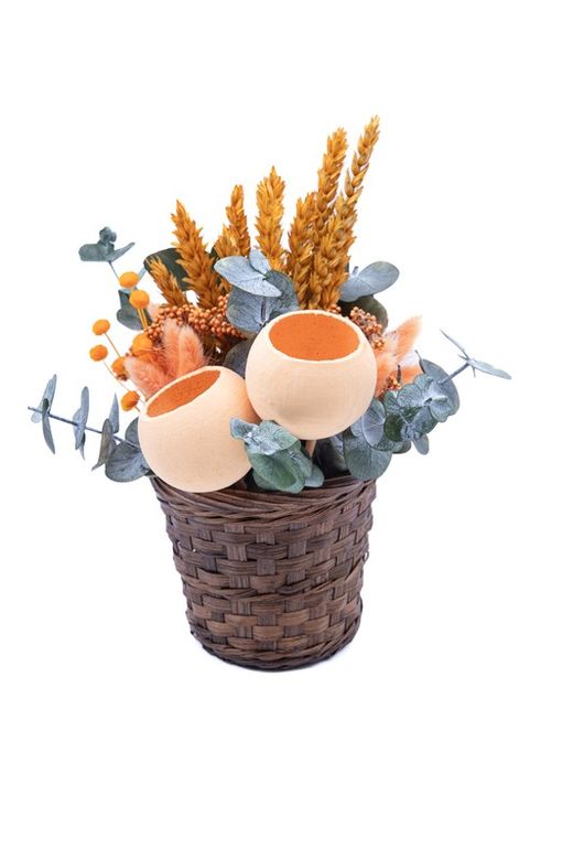 Cesto natural oscuro con flores secas y preservadas en tonos naranjas