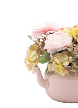 Dulce centro floral artificial en tonos rosa claros.