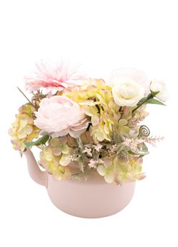 Dulce centro floral artificial en tonos rosa claros.