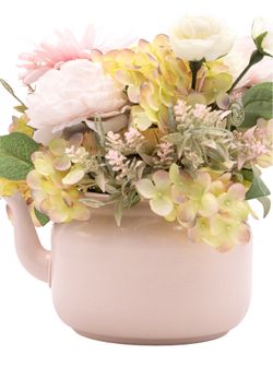 Dulce centro floral artificial en tonos rosa claros.