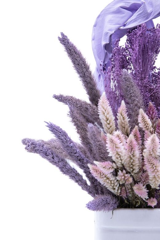 Elegante centro de cerámica blanca con flores lilas y rosadas