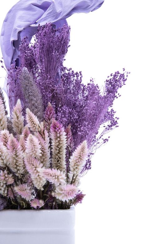 Elegante centro de cerámica blanca con flores lilas y rosadas