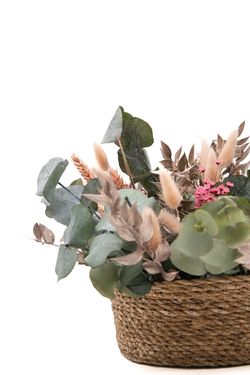 Encantadora cesta de fibra natural de flores secas y preservadas rosadas