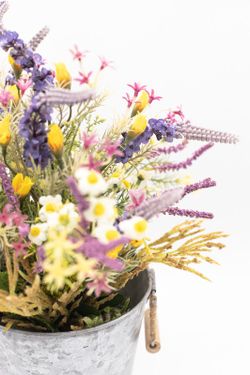 Flores silvestres en color lila en macetero de metal