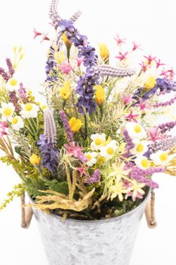 Flores silvestres en color lila en macetero de metal