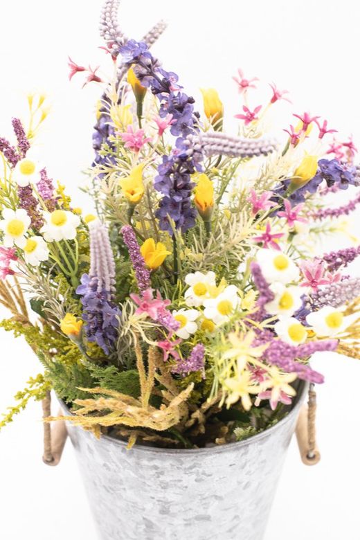 Flores silvestres en color lila en macetero de metal