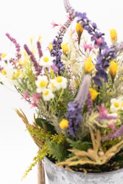 Flores silvestres en color lila en macetero de metal