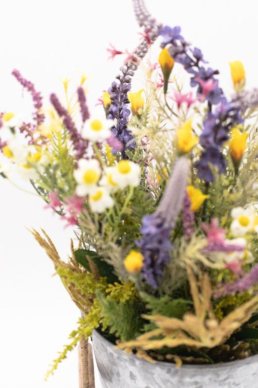Flores silvestres en color lila en macetero de metal