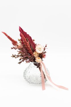 Jarrón vintage con flores preservadas y flores secas en color rosado.