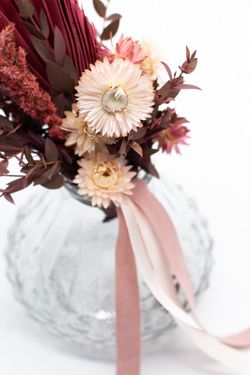 Jarrón vintage con flores preservadas y flores secas en color rosado.