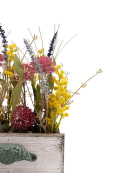 Sofisticado centro de flores artificiales en tonos morados y mimosa