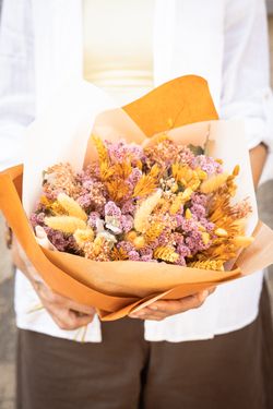 Vibrante ramo de flores secas y preservadas en tonos lila y naranja