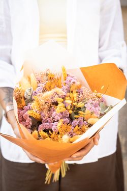 Vibrante ramo de flores secas y preservadas en tonos lila y naranja