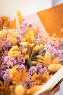 Vibrante ramo de flores secas y preservadas en tonos lila y naranja